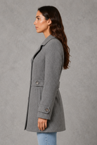 Women’s tailored longline coat with a classic collar, button-front fastening, defined waist, decorative waist tabs and button cuff detailing.