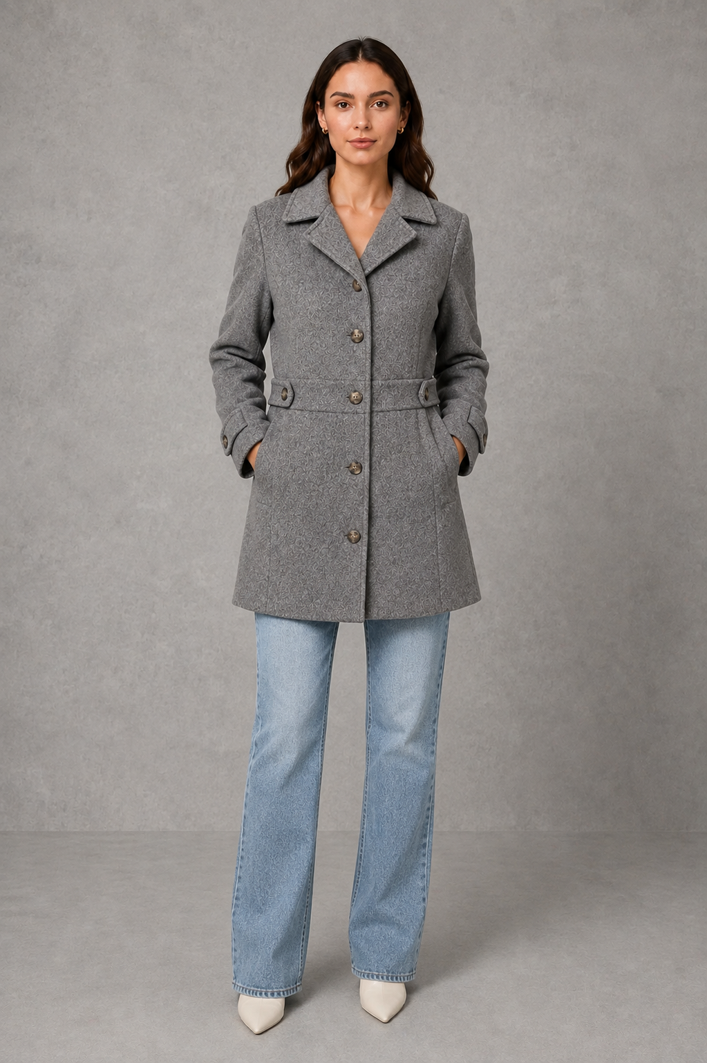 Women’s tailored longline coat with a classic collar, button-front fastening, defined waist, decorative waist tabs and button cuff detailing.