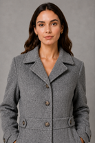 Women’s tailored longline coat with a classic collar, button-front fastening, defined waist, decorative waist tabs and button cuff detailing.