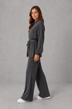 Women’s turtleneck knit two piece set with a belted long sleeve ribbed top and matching wide leg trousers for autumn and winter.