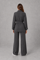 Women’s turtleneck knit two piece set with a belted long sleeve ribbed top and matching wide leg trousers for autumn and winter.