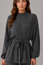 Women’s turtleneck knit two piece set with a belted long sleeve ribbed top and matching wide leg trousers for autumn and winter.