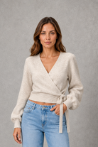 Women’s V-neck wrap knit jumper with long sleeves, crossover front and adjustable tie waist bow.