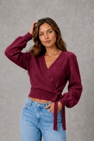 Women’s V-neck wrap knit jumper with long sleeves, crossover front and adjustable tie waist bow.