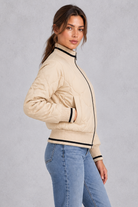 Women’s quilted bomber jacket with wave-stitch detailing, a high ribbed collar, full zip front, extended cuffs and contrast trims.
