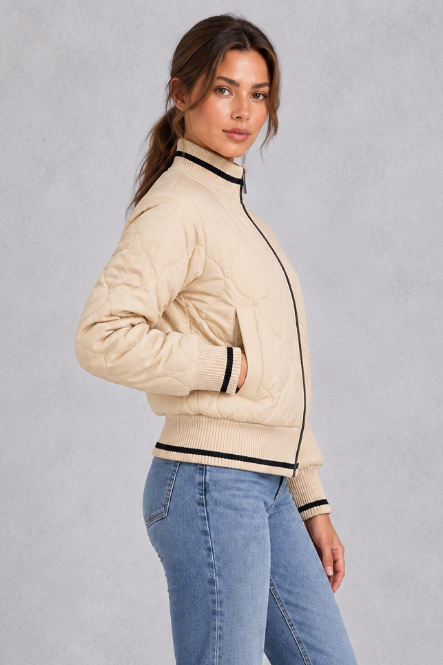 Women’s quilted bomber jacket with wave-stitch detailing, a high ribbed collar, full zip front, extended cuffs and contrast trims.