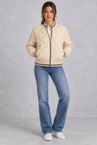Women’s quilted bomber jacket with wave-stitch detailing, a high ribbed collar, full zip front, extended cuffs and contrast trims.