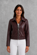 Women’s wine leather-look jacket with a tailored silhouette and front zip fastening, styled as an elegant biker-inspired autumn jacket.