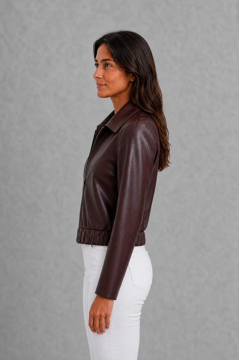 Women’s wine leather-look jacket with a tailored silhouette and front zip fastening, styled as an elegant biker-inspired autumn jacket.