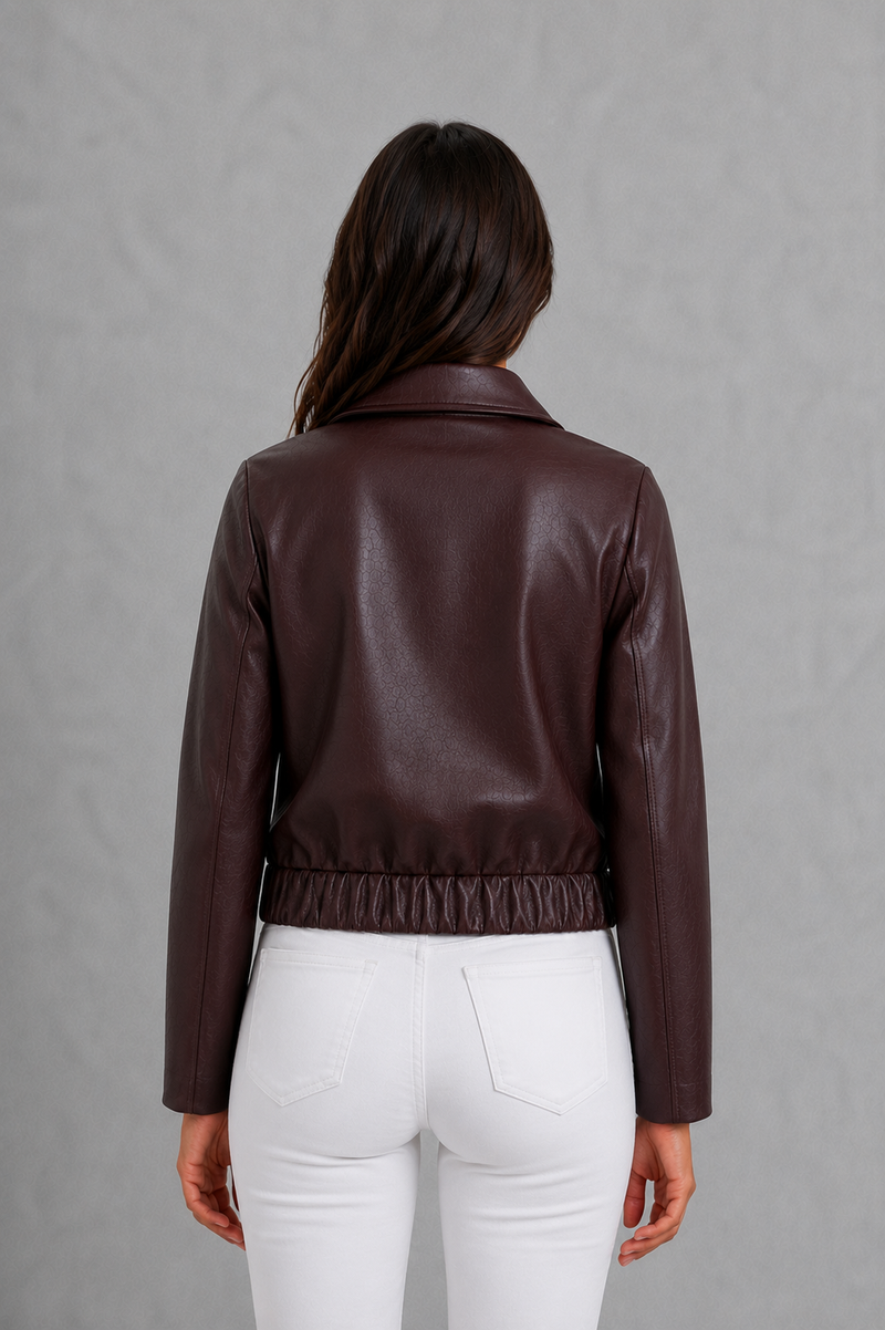 Women’s wine leather-look jacket with a tailored silhouette and front zip fastening, styled as an elegant biker-inspired autumn jacket.