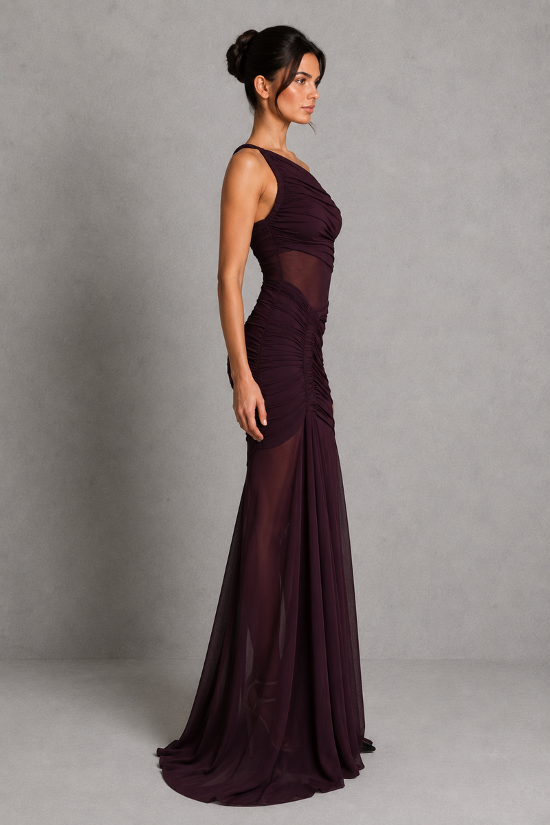 Woman wearing a burgundy evening gown against a gray background