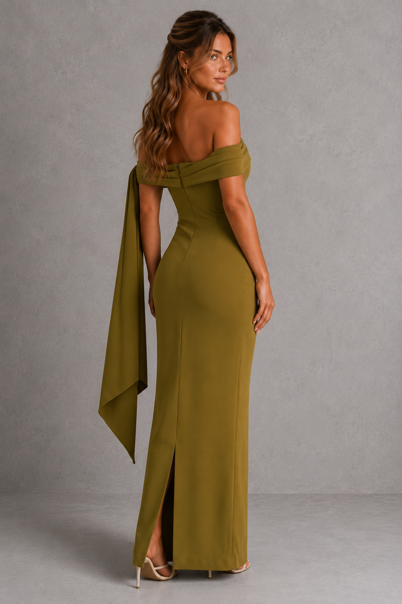 Woman wearing a green off-shoulder gown with a slit on a gray background