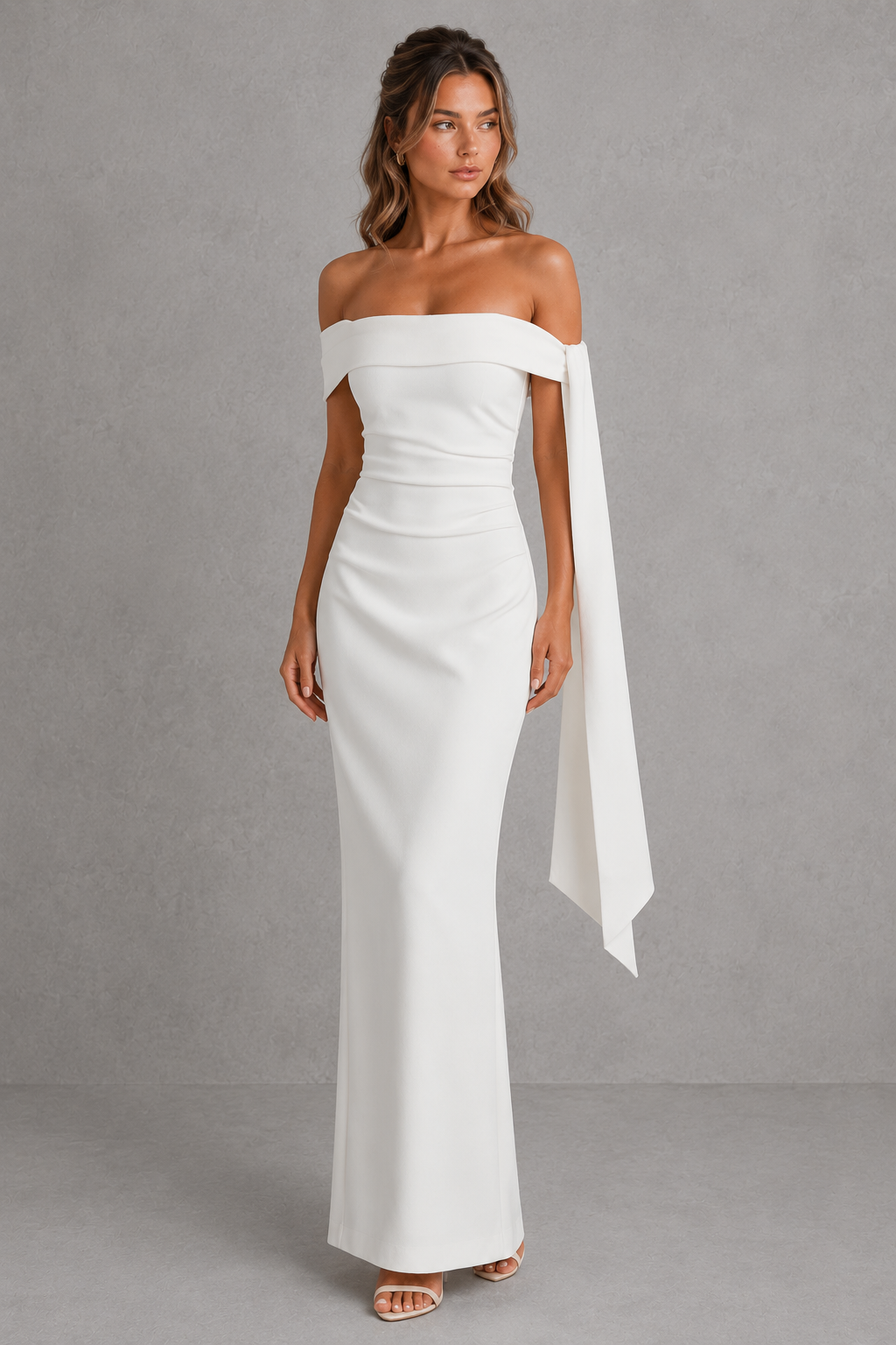 Woman wearing a white strapless gown with a draped fabric on a gray background