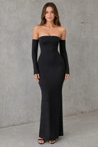 Woman wearing a black off-shoulder gown against a gray background