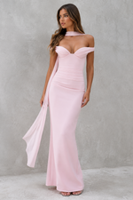 Woman wearing a pink off-shoulder gown against a gray background