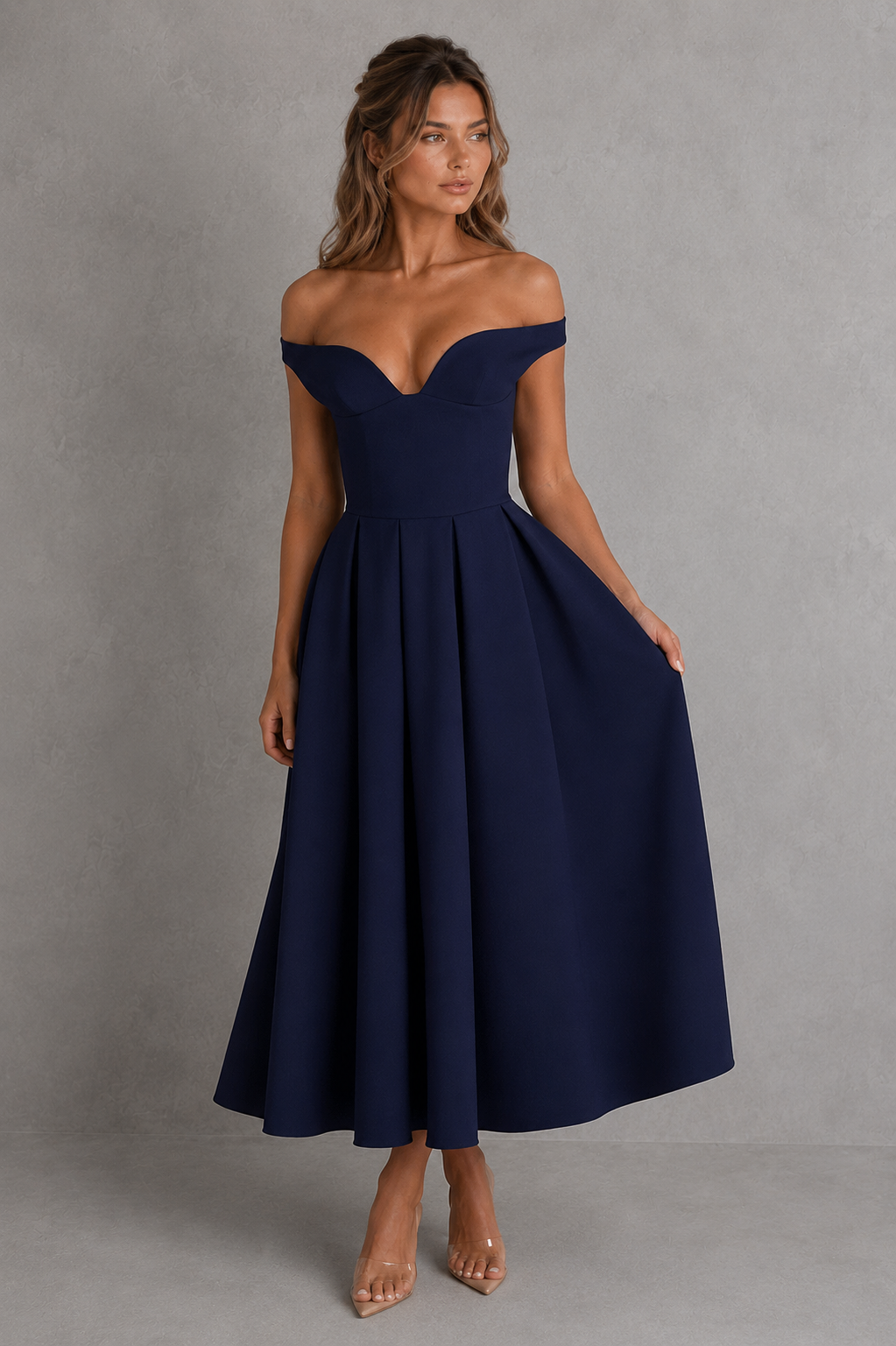 Woman wearing a navy off-shoulder dress against a gray background