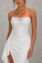 White strapless dress with sequin bodice on a gray background