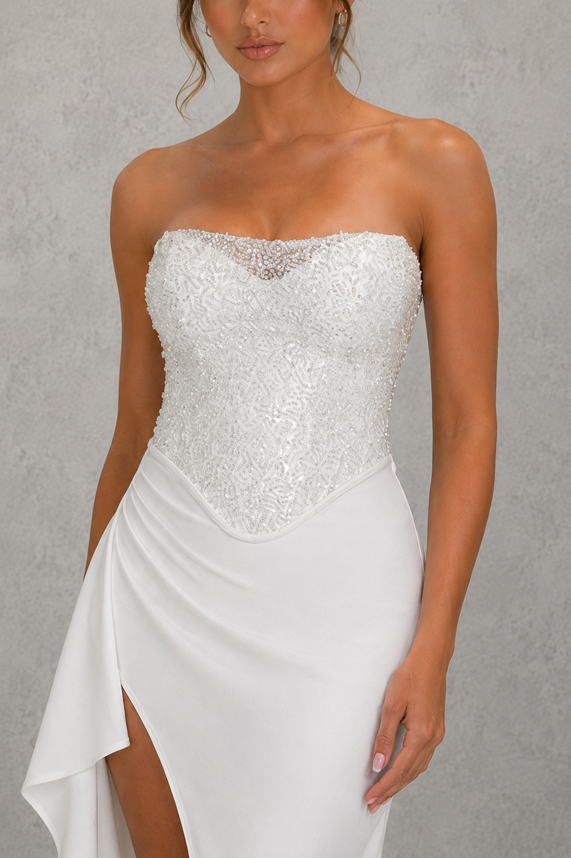 White strapless dress with sequin bodice on a gray background