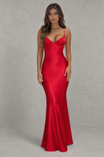Woman wearing a red satin evening gown against a gray background