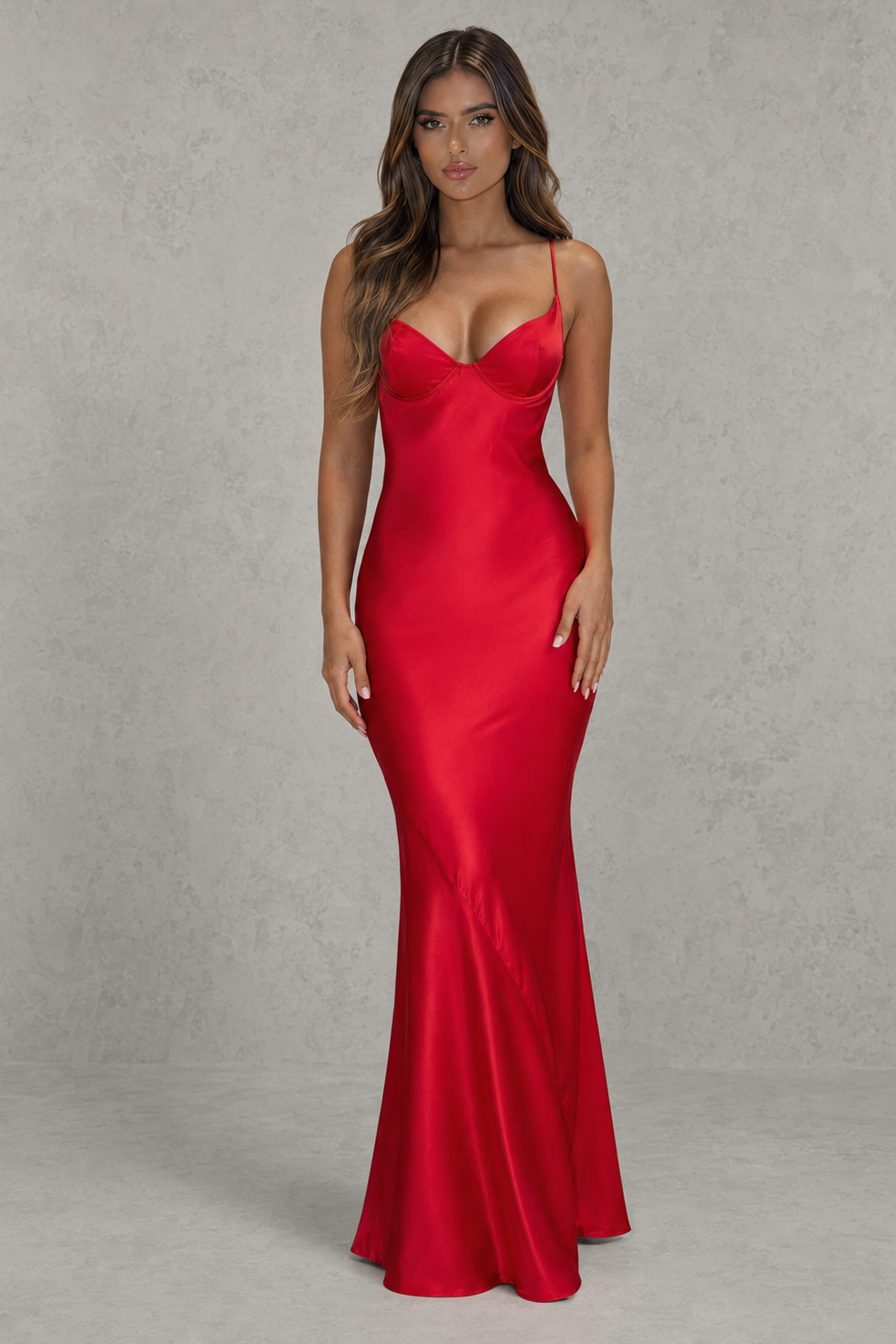Woman wearing a red satin evening gown against a gray background