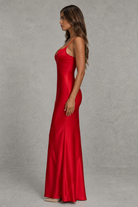 Woman wearing a red evening gown against a gray background