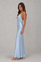 Woman wearing a light blue evening gown against a gray background