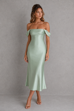 Woman wearing a light green off-shoulder dress against a gray background