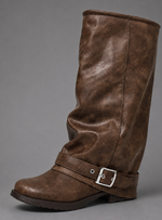 Women’s black slouchy knee-high boots with buckle strap, round toe, low block heel and chunky lug-tread sole.