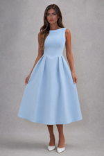 Woman wearing a light blue dress against a gray background