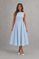 Woman wearing a light blue dress against a gray background