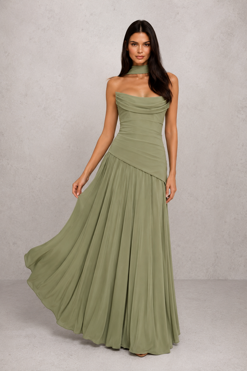 Woman wearing a green strapless gown against a plain background