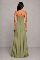 Woman wearing a strapless green dress against a gray background