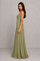 Woman wearing a green strapless gown against a gray background