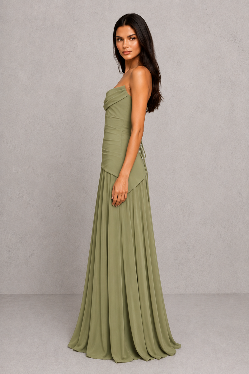 Woman wearing a green strapless gown against a gray background