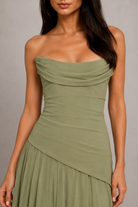 Woman wearing a strapless green dress against a neutral background
