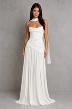 Woman wearing a white strapless gown against a gray background