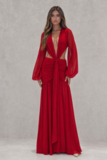 Woman wearing a red dress with long sleeves against a gray background