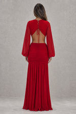 Red evening gown with long sleeves and open back on a plain background