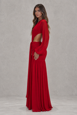 Woman wearing a red dress with long sleeves and a cutout design on a gray background