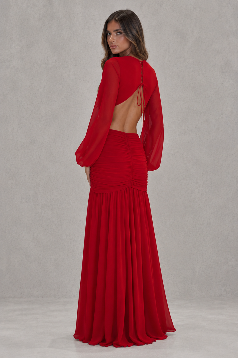 Red evening gown with sheer sleeves on a plain background