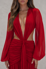 Red outfit with a deep neckline and long sleeves on a neutral background