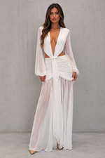 Woman wearing a white, sheer outfit against a gray background