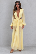 Woman wearing a yellow outfit with a plain background