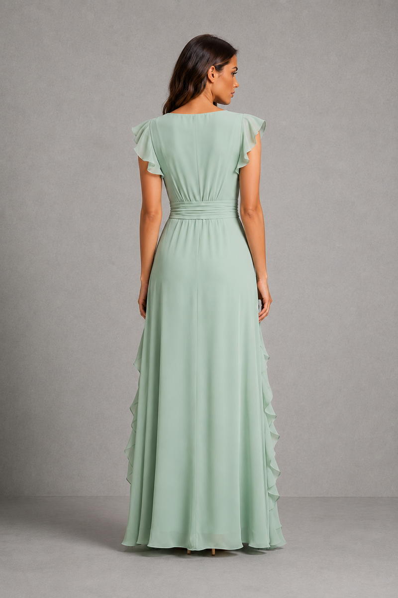 A woman viewed from the back wearing a floor-length sage green dress with ruffled cap sleeves, a gathered waist, and layered ruffle detailing along the skirt, photographed against a plain gray studio backdrop.