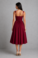 Woman wearing a burgundy dress against a gray background