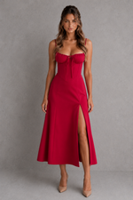 Woman wearing a red dress with a slit on a gray background