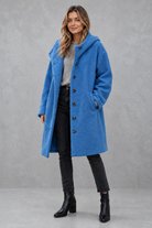 Women's elegant button-front autumn and winter coat with a relaxed fit, classic longline silhouette, soft warm fabric, long sleeves and timeless design, ideal for layering with knitwear, dresses or tailored outfits.