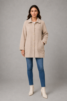 Women’s elegant oversized mid-length coat with spacious pockets and refined cuff detailing, designed for stylish autumn and winter layering.