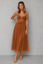 Woman wearing a brown dress against a gray background
