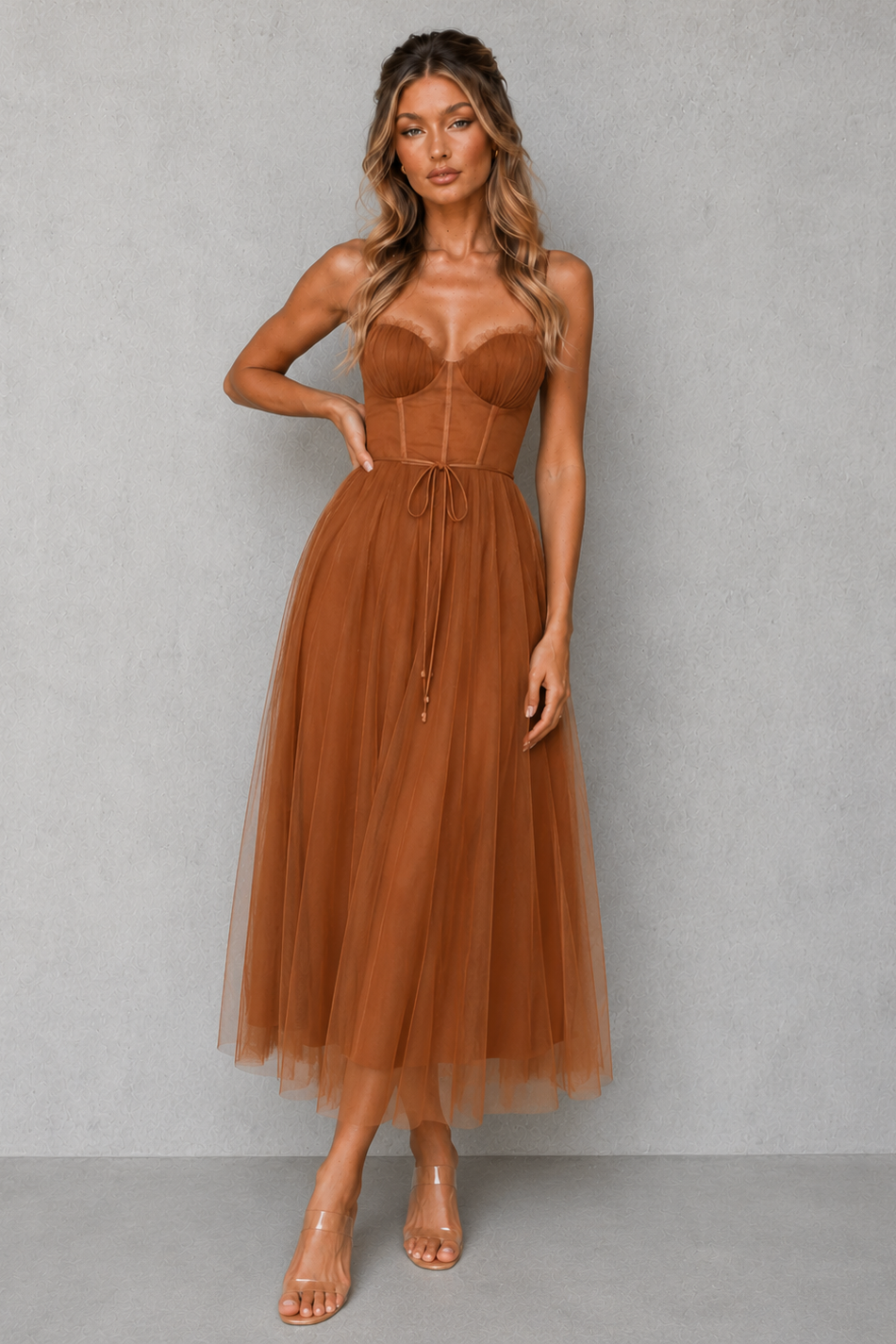 Woman wearing a brown dress against a gray background